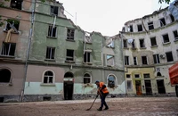 Công nhân quét dọn bên ngoài một tòa nhà chung cư ở thành phố Lviv (phía tây Ukraine) vào ngày 7-7, một ngày sau khi tòa nhà bị tên lửa tấn công. Ảnh: AFP