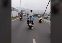 Để con đứng trên yên, không đội mũ bảo hiểm khi xe đang chạy