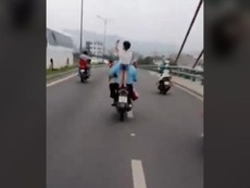 Để con đứng trên yên, không đội mũ bảo hiểm khi xe đang chạy