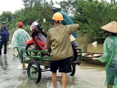 Chở xe máy qua đoạn lũ ngập kiếm tiền triệu