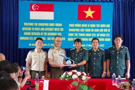 Đại tá Đinh Đức Việt - Phó Chính uỷ Sư đoàn 372 tặng quà kỷ niệm cho đoàn sĩ quan trẻ Quân đội Singapore. Ảnh: Đức Cầu.
