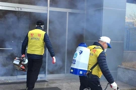 Các quan chức kiểm dịch khử trùng một nhà thờ Shincheonji ở phía đông nam thành phố Daegu hôm 23-2. Ảnh: YONHAP