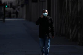 Nam thanh niên đeo khẩu trang đi trên phố Regent không một bóng người ở London, Anh, ngày 13-4. Ảnh: REUTERS