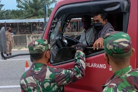 Binh sĩ kiểm tra việc chấp hành hạn chế đi lại trên một đường cao tốc ở TP Pekanbaru (Indonesia) ngày 22-4. Ảnh: GETTY IMAGES