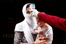 Một phụ nữ ở New Delhi, Ấn Độ được đo thân nhiệt vào ngày 20-4. Ảnh: REUTERS