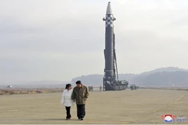 Hai cha con ông Kim Jong-un nắm tay đi thị sát bãi phóng tên lửa. Ảnh: KCNA