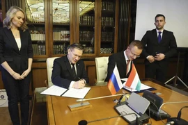 Ngoại trưởng Hungary Peter Szijjarto (ngồi, phải) và Giám đốc điều hành Tập đoàn năng lượng nguyên tử quốc gia Nga Rosatom Alexey Likhachev đang ký kết một thỏa thuận tại Moscow hôm 11-4. Ảnh: Ivan Fedorenko/PHÒNG TRUYỀN THÔNG TẬP ĐOÀN ROSATOM/AP