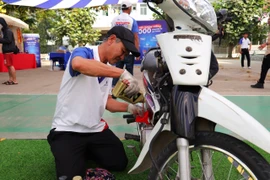 1.000 thanh niên, công nhân được kiểm tra và thay nhớt xe miễn phí trước khi về quê ăn Tết.