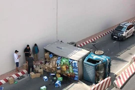 Xe tải lật, người dân giúp tài xế gom hàng hóa