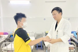 Bác sĩ thăm khám cho bệnh nhân 10 tuổi sau phẫu thuật do đột quỵ. Ảnh: MT.