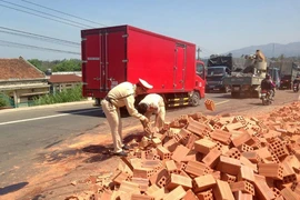 Ô tô tải lật nhào, gạch tràn ra đường