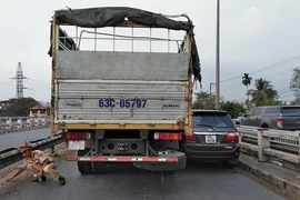Xe tải kẹp ô tô 7 chỗ vào thành cầu