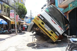Xe tải sụp hố ga lật chổng vó giữa phố Sài Gòn