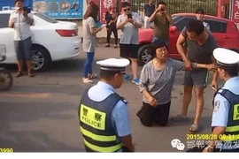 Cảnh sát giao thông quỳ xuống đất để giải thích cho dân