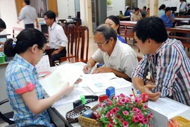 Người dân làm thủ tục tại phòng công chứng số 4, TP.HCM. Ảnh: HTD