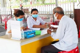 Người dân đang lãnh lương hưu tại điểm chi trả.