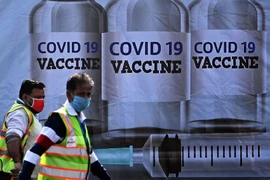 Người dân Nam Phi đi ngang qua một bảng tuyên truyền về vaccine COVID-19 ở thủ đô Cape Town hồi tháng 1-2021.