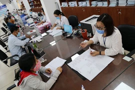Cán bộ khu vực III TP Thủ Đức giải quyết thủ tục hành chính cho người dân. Ảnh: HOÀNG GIANG