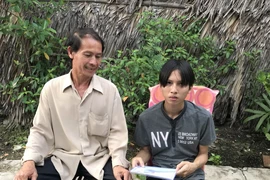 Em Trương Thanh Tài cùng cha vui mừng vì đã được cấp giấy khai sinh.