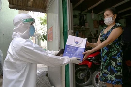 Nhân viên y tế phát thuốc cho F0 điều trị tại nhà ở phường 12, quận Bình Thạnh, TP.HCM.