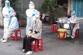  Nhân viên y tế của Trạm y tế phường 4, quận Tân Bình lấy mẫu xét nghiệm cho F0 cách ly tại nhà.