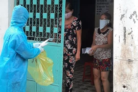 F0 đang cách ly tại nhà ở TP.HCM được nhân viên y tế phát thuốc. 