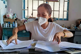 Bà S bên đống hồ sơ sau gần hai năm chưa được giao con theo bản án của tòa.