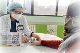 Bác sĩ Trung tâm hô hấp BV Bạch Mai (Hà Nội) kiểm tra độ bão hòa ôxy trong máu mao mạch cho bệnh nhân sau nhiễm COVID-19.