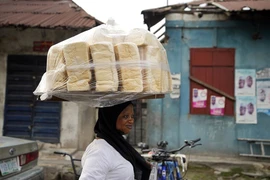 Một phụ nữ bán bánh mì trên đường phố TP Lagos (Nigeria) ngày 3-2.