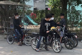 Các học sinh tụ tập thử xe đạp điện.