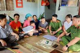 Thiếu tá Lê Tấn Thành (bìa phải) cùng đại diện lãnh đạo địa phương, Công an xã Ea Uy trao tiền vận động cho gia đình chị Lý Thị Lan.