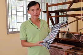 Anh Phạm Thanh An, Chủ nhiệm Hợp tác xã dệt choàng Long Khánh, cùng chiếc khăn rằn là sản phẩm của hợp tác xã.