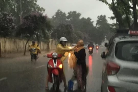 'Phát sốt' với cô gái dừng xe giữa trời mưa lớn mặc áo mưa cho cụ già