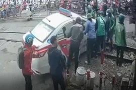 Xe taxi kẹt ở đường ray khi tàu hỏa đang tới