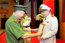 Thừa ủy quyền của Chủ tịch nước, Bộ trưởng Tô Lâm trao quyết định thăng cấp bậc hàm Trung tướng đối với Thiếu tướng Tô Ân Xô. Ảnh: BCA