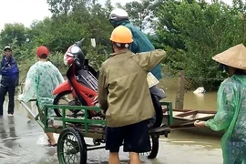 Chở xe máy qua đoạn lũ ngập kiếm tiền triệu