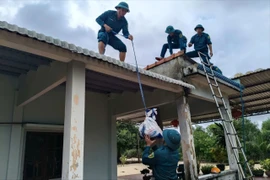 Dân quân giúp dân chằng chống nhà cửa ứng phó bão số 12