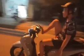 Thanh niên buông 2 tay, dùng chân lái xe máy