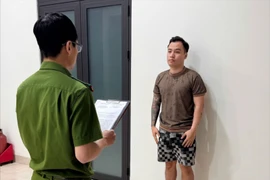 Cảnh sát đọc lệnh bắt đối với Dương. Ảnh: CA