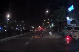 Hai người đi xe máy ngã nhào ra đường. Ảnh: TN