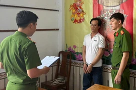 Công an đọc lệnh bắt bị can Huy. Ảnh: CA