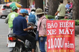 Người dân mua bảo hiểm xe tại TP. HCM. Ảnh:HOÀNG GIANG