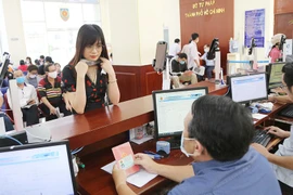 Người dân mang theo sổ hộ khẩu khi làm thủ tục hành chính ở Sở Tư pháp TP.HCM. Ảnh: HOÀNG GIANG