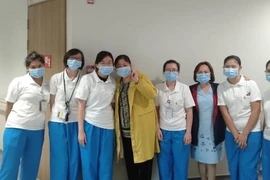 Bà Giang chụp ảnh cùng các y bác sĩ điều trị cho mình tại Trung tâm Phòng chống bệnh truyền nhiễm Singapore. Ảnh: CNA