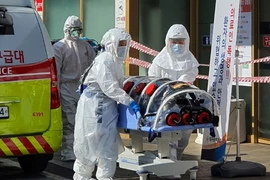 Nhân viên y tế di chuyển một người nghi nhiễm COVID-19 ở TP Daegu hôm 21-2. Ảnh: AFP