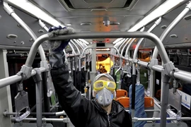 Một nhân viên y tế khử trùng một xe buýt ở thủ đô Tehran (Iran) ngày 28-2. Ảnh: AFP