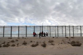 Người di cư từ Trung Mỹ đi dọc bức tường biên giới giữa Mỹ và Mexico. Ảnh: GETTY IMAGES