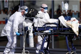 Nhân viên y tế di chuyển một bệnh nhân nhiễm COVID-19 ở TP Strasbourg, Pháp ngày 16-3. Ảnh: REUTERS