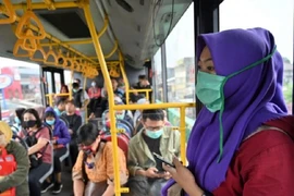 Người dân Indonesia đeo khẩu trang trên xe buýt như một biện pháp phòng dịch COVID-19. Ảnh: AFP