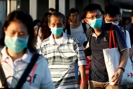 Người dân đeo khẩu trang ở Singapore, ngày 21-3. Ảnh: AFP